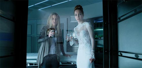 Zoie Palmer and Ksenia Solo watch HELP appear on a glass door