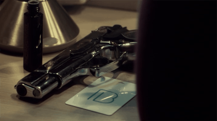 Beth's gun and a card with a symbol on it.