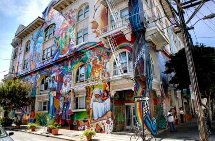 a 3 story building covered with colorful murals