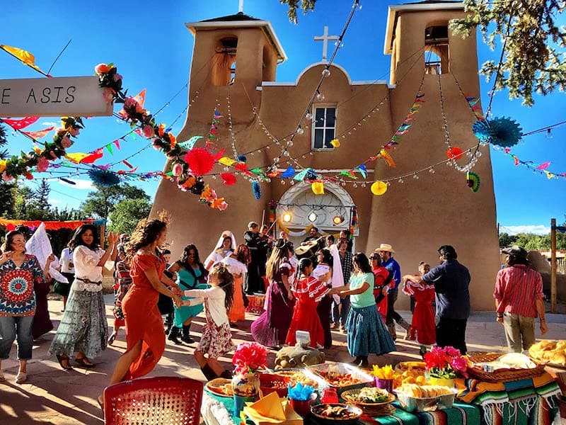 A fiesta in front of an adobe church